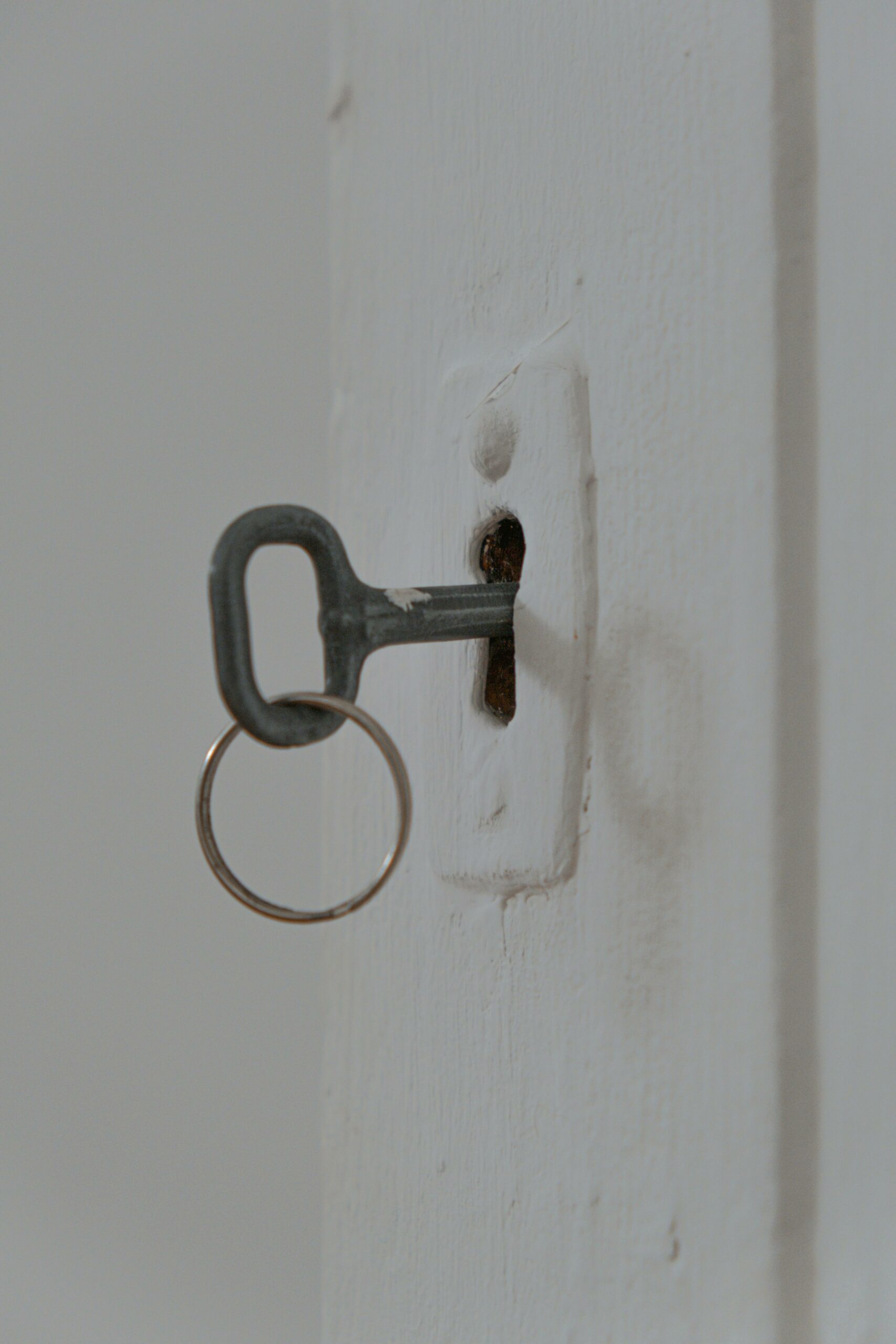 Schlüssel im Schlüsselloch einer weißen Tür