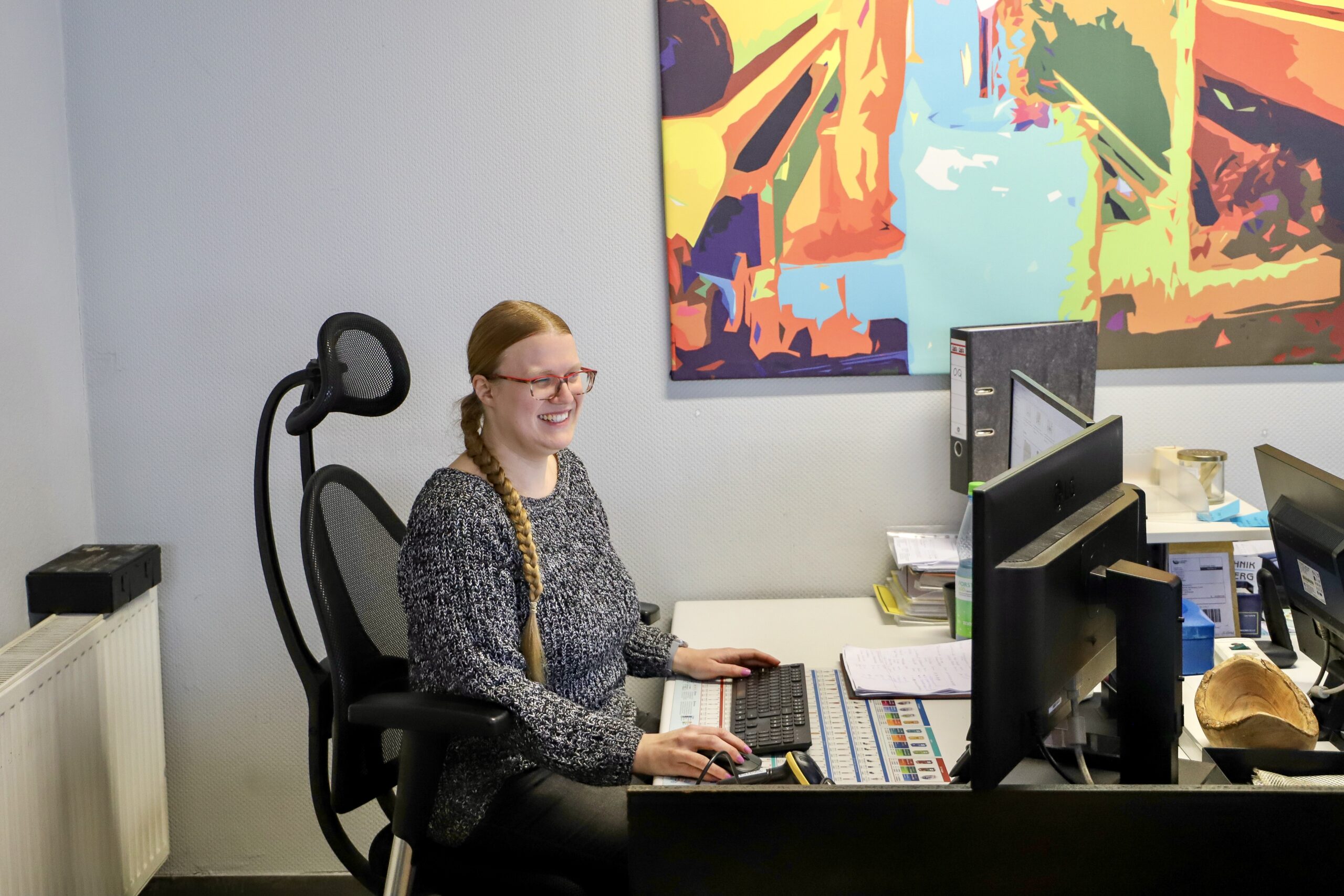 Frau arbeitet an einem Schreibtisch mit Computer