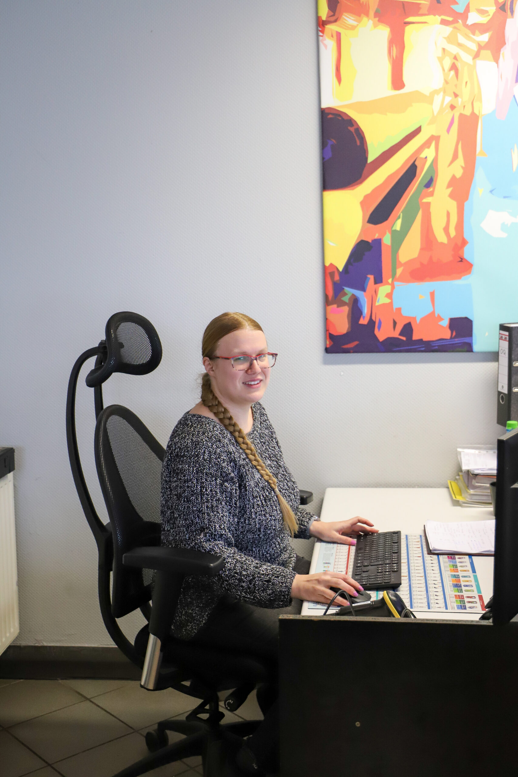 Frau arbeitet am Schreibtisch sitzend am Computer